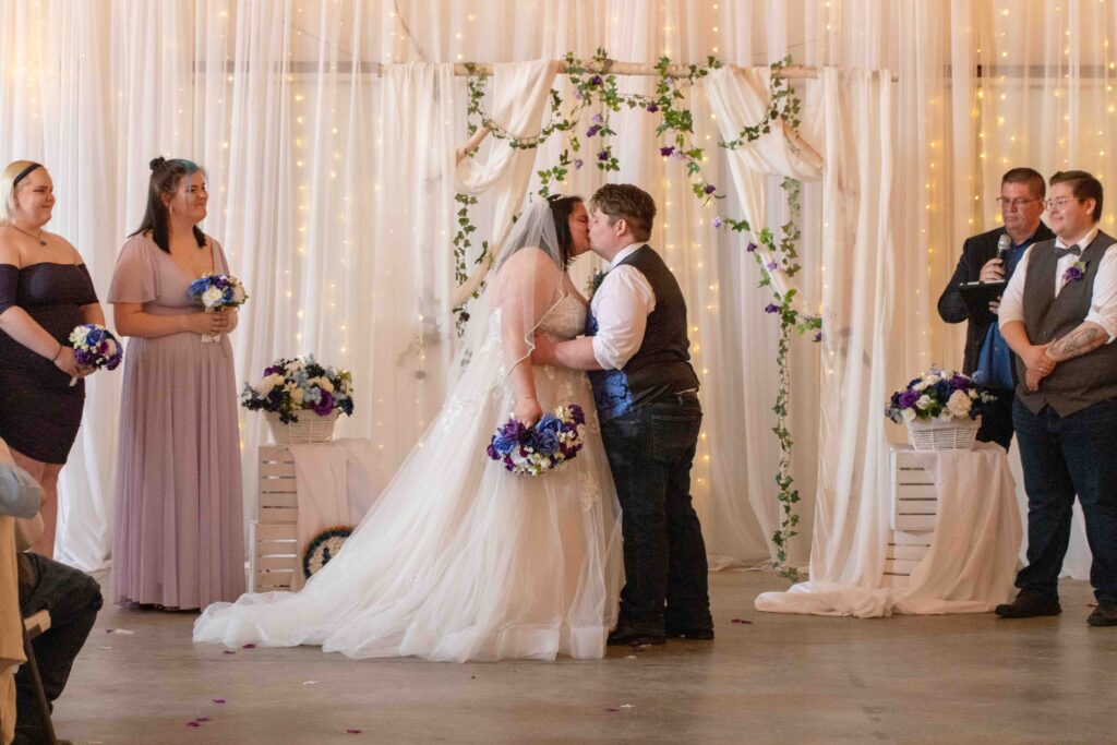 bride and groom first kiss at lakeside wedding venue