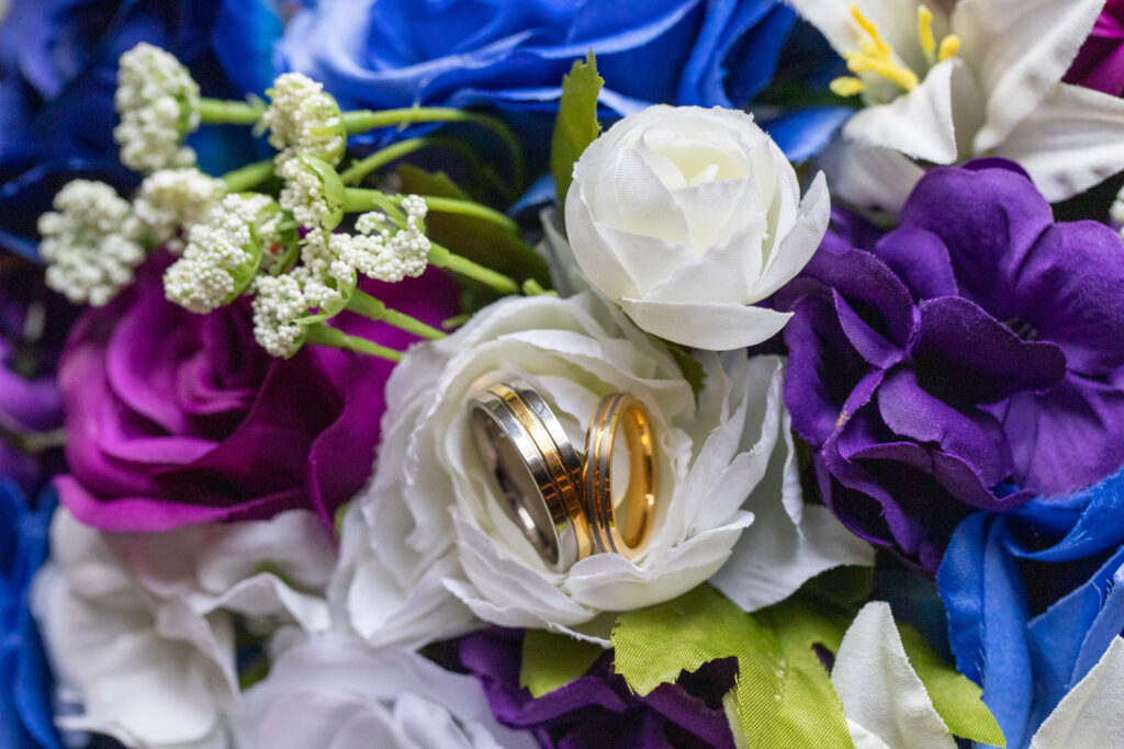 blue purple and white flowers with wedding rings