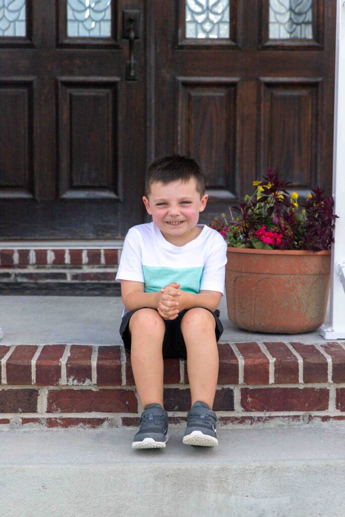 little boy sitting on porch steps